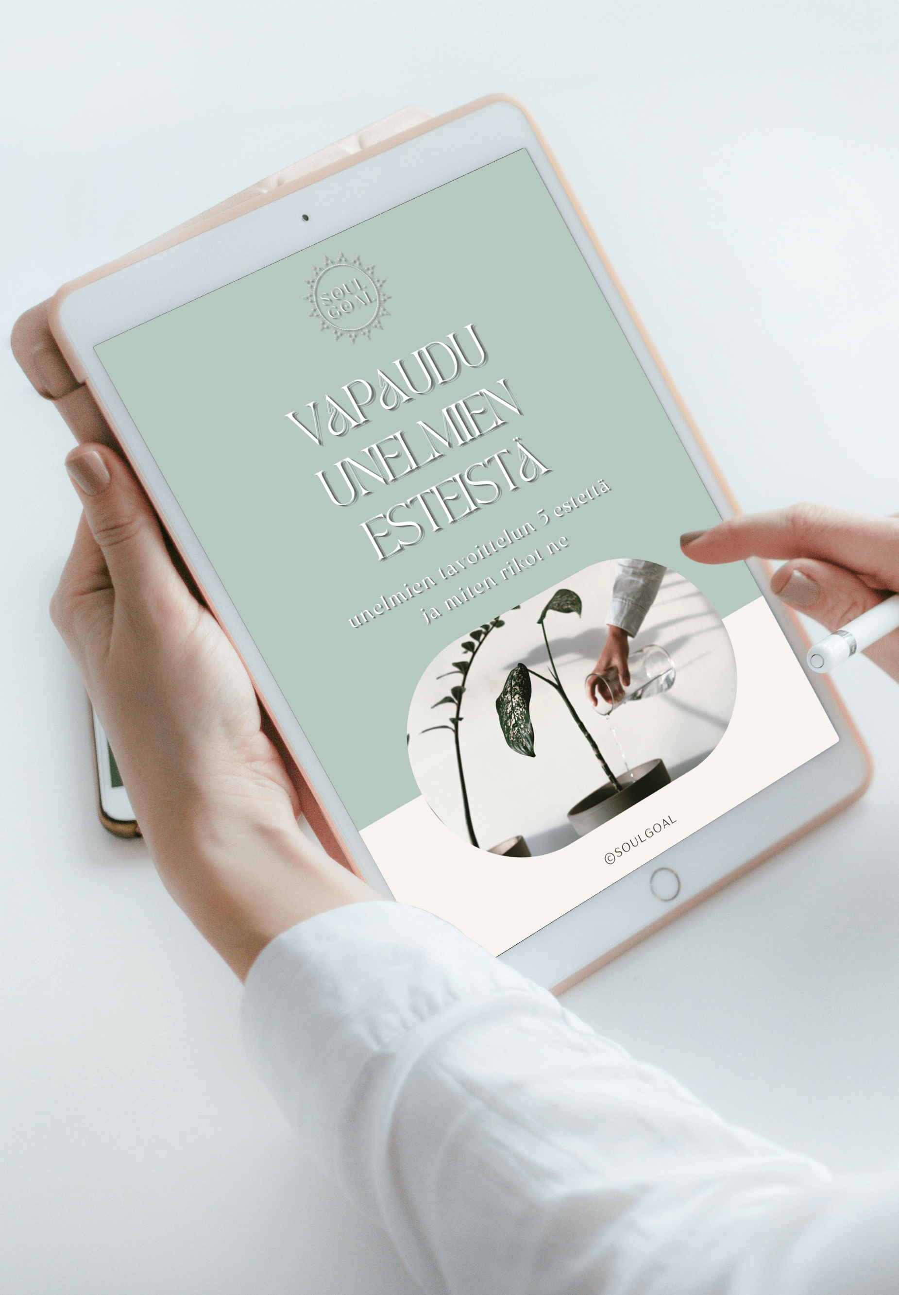 Ihmisen käsissä iPad, jossa näkyy kansilehti Vapaudu-unelmien esteistä-kurssille